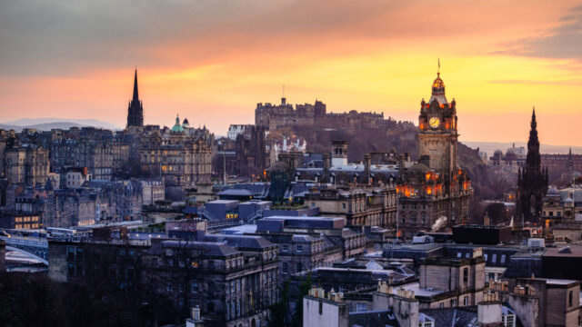 Gray-blue city buildings on hill at sunrise