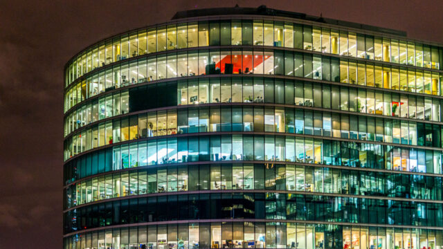 A large office building at night with multiple lights on