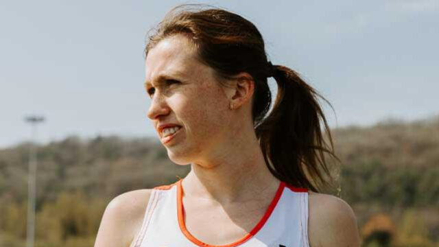 Clara Evans - A young female athlete with long hair tied back is looking off to the side, wearing a sports tank top.