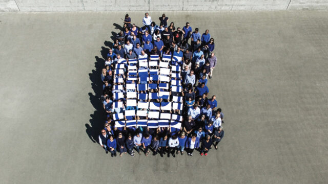 Overhead view of Tetra Tech employees holding up paper pieces forming company logo