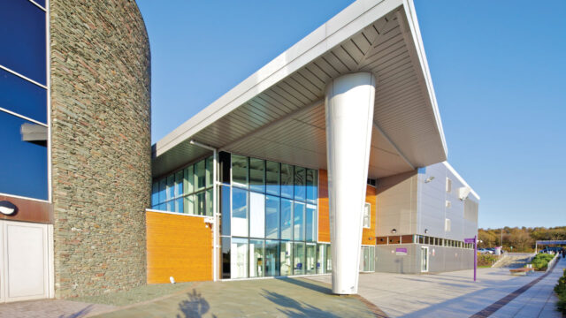 Exterior view of the entrance of a modern style educational building with floor-to-ceiling windows