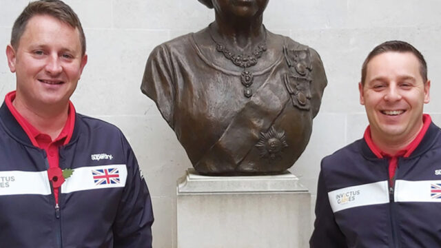 David and Antony Morris wearing Invictus Games jackets next to a bust of Queen Elizabeth II