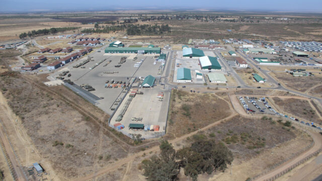 Aerial view of the green buildings and parking lot of a military training ground