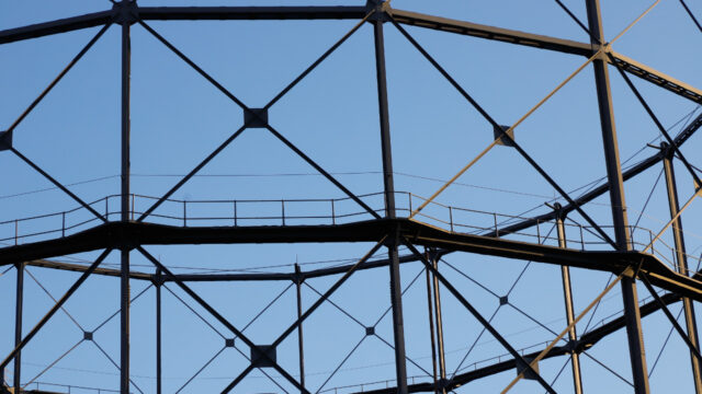 A round tower of metal scaffolding against a clear blue sky