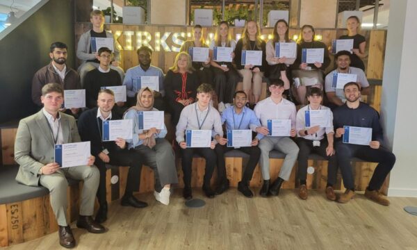Tetra Tech Early Careers Graduates sat together with their certificates - A group photo of individuals holding certificates, smiling.