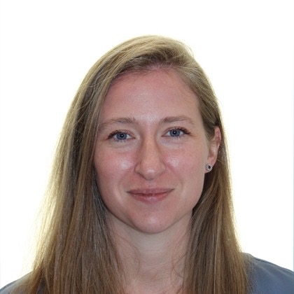 Portrait of a woman with long blonde hair and blue eyes, smiling softly against a white background.